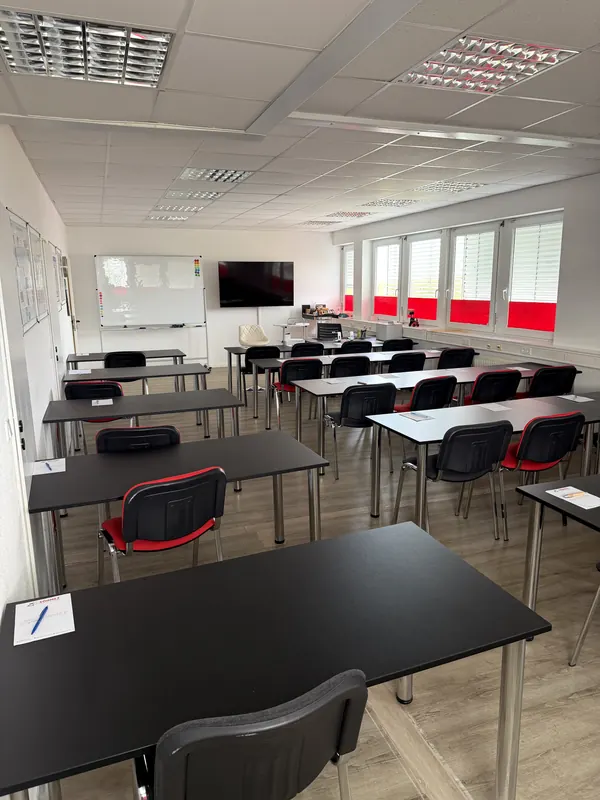 Redovi stolova s crvenim i crnim stolicama, pogled prema naprijed
